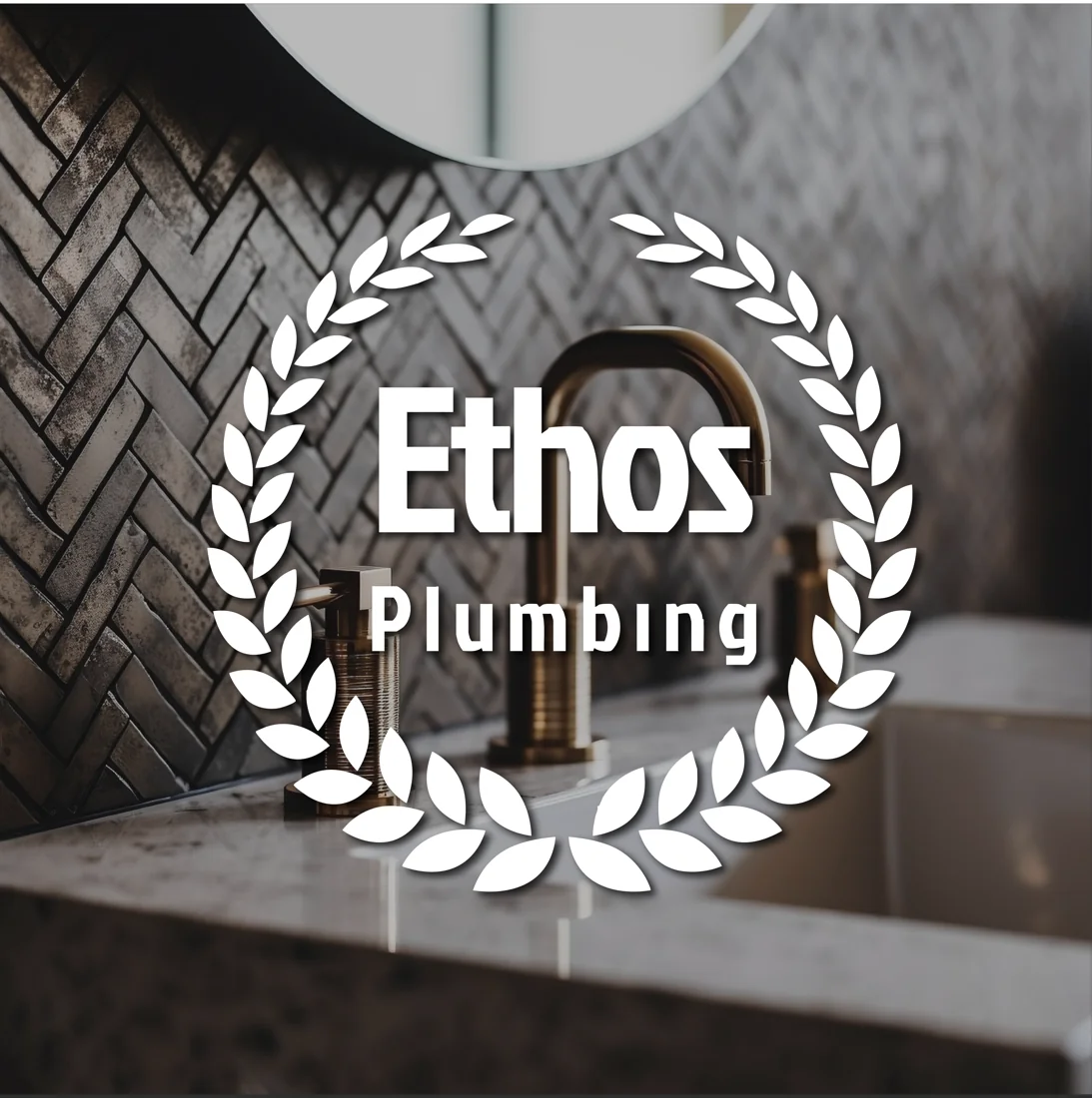 Ethos Plumbing branding over a bathroom sink and brass faucet